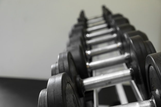 Free photo dumb bells lined up in a fitness studio. picture is short focus