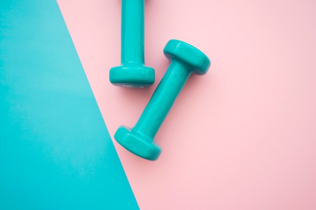 Dumbbells on blue and pink background