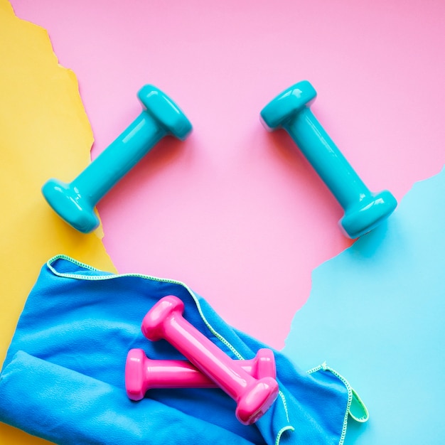 Dumbbells and towel on colorful background