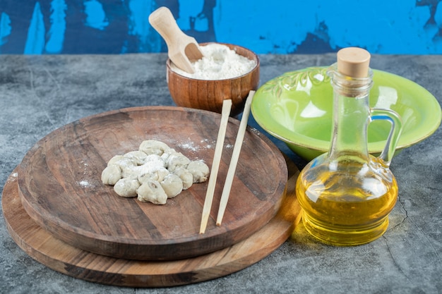 Free photo dumpling plate with bowl of flour and olive on marble table.