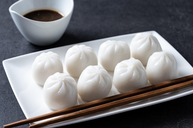 Dumplings in bamboo steamer on black stone background