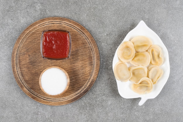 Free photo dumplings stuffed with meat on white plate with sauces