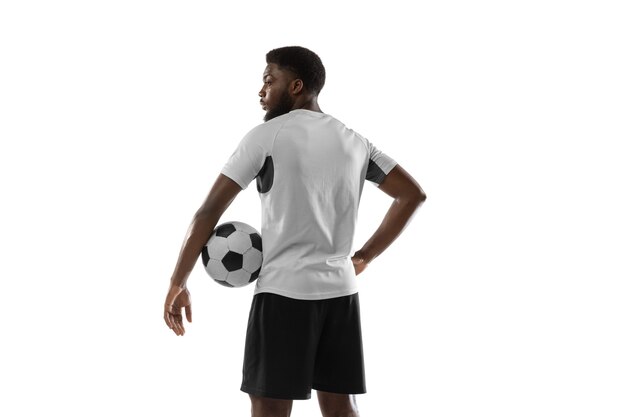 Dynamic. Young African man, male football soccer player training isolated.