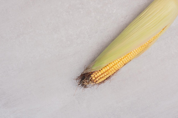 Free photo ear of fresh corn on white table.