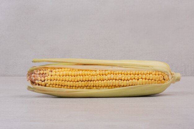 Ear of fresh corn on white.