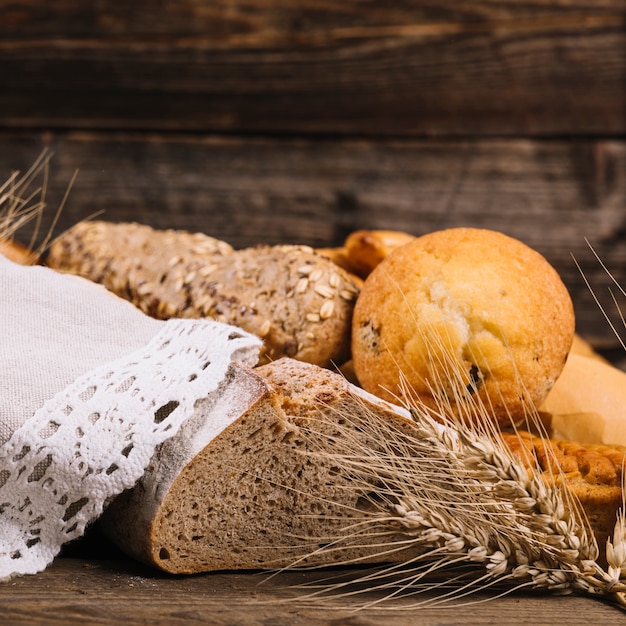 Foto gratuita spiga di grano con pane cotto sul tavolo di legno