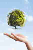 Free photo earth day campaign hand showing tree in a bubble media mix