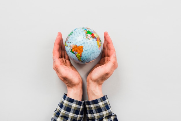 Earth globe surrounded by hands