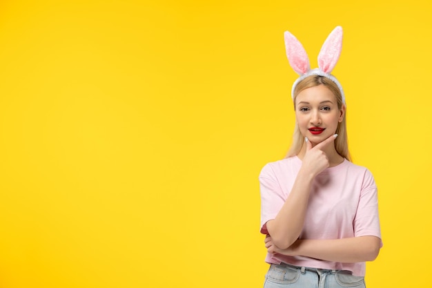 Easter adorable pretty young blonde girl with bunny ears smiling with hand on chin