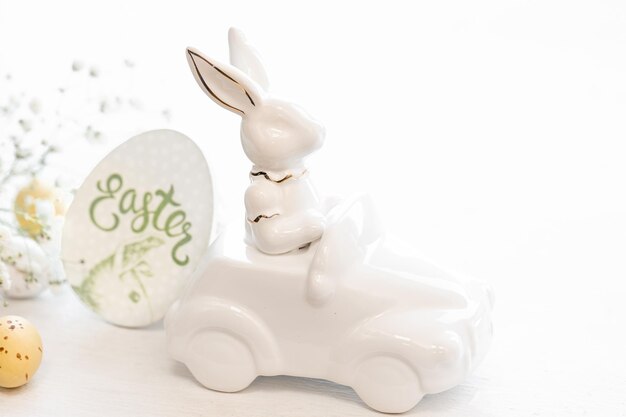 Free photo easter background with a ceramic hare in the car and eggs on a white background