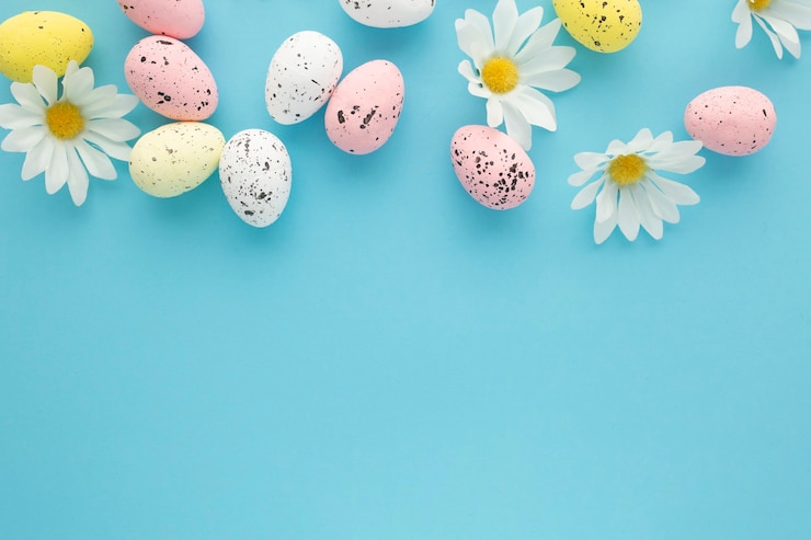 Free Photo easter background with eggs and daisies on a blue background with copy space