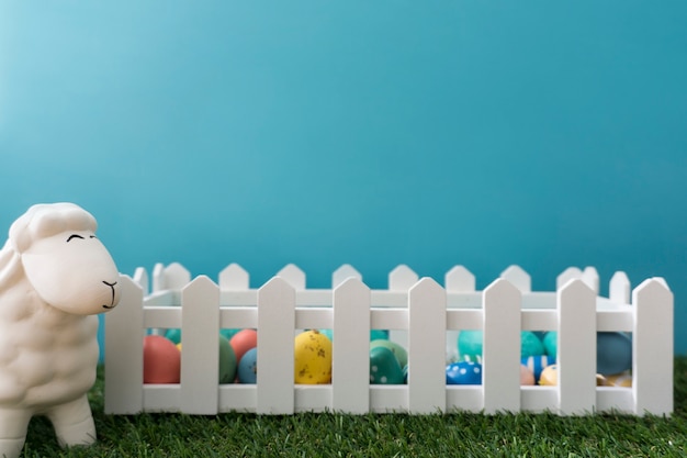 Easter background with sheep next to a wooden fence