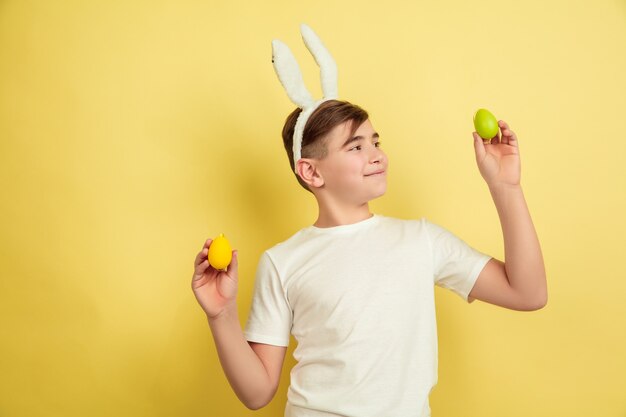 Пасхальный кролик мальчик с яркими эмоциями на желтом