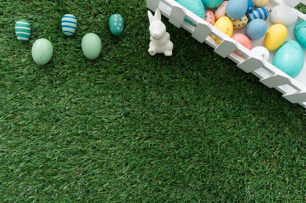 Easter bunny and colored eggs on grass surface