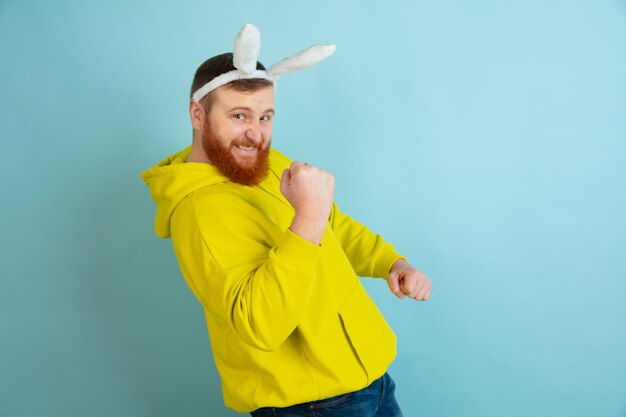 Free photo easter bunny man with bright emotions on blue studio background