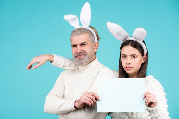 Easter bunny man and woman hold board board for text