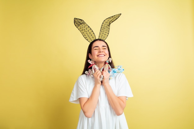 Free photo easter bunny woman with bright emotions on yellow studio