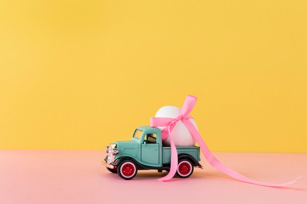 白い卵とピンクのリボンのイースター車