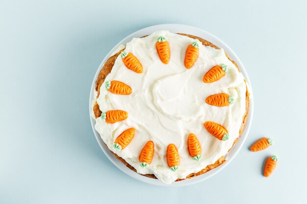 Easter carrot cake with frosting on blue table