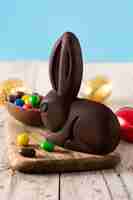 Free photo easter chocolate bunny and colorful eggs on wooden table