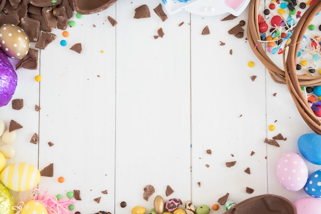 Easter chocolate eggs with candies on wooden table 