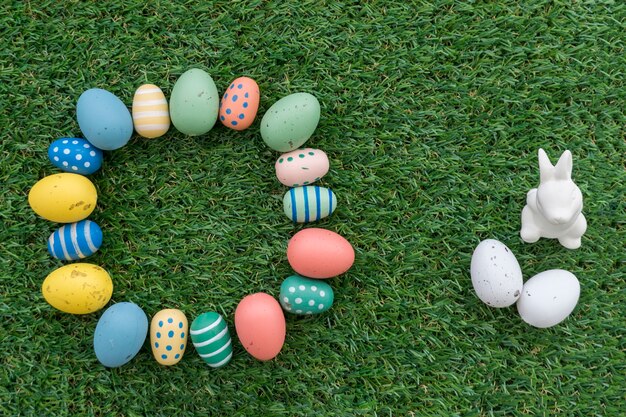 Easter composition with circle of eggs and decorative rabbit