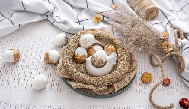 Easter composition with decorated Easter eggs in a nest among flowers