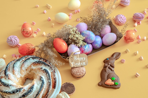 Free photo easter composition with eggs and cupcake on colored.