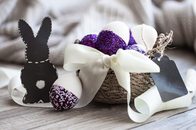 Easter composition with eggs decorated with purple sparkles