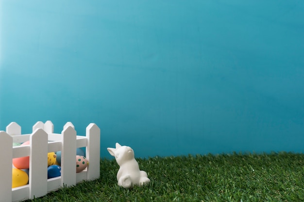 Composizione di Pasqua con coniglio vicino ad una recinzione di legno