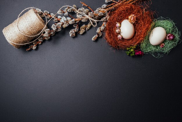 Easter concept, eggs, branches of the pussy willow on black background. 