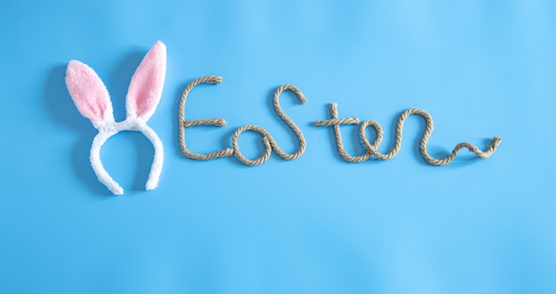 Easter creative inscription on blue with items of Easter decor.