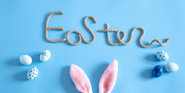 Easter creative inscription on blue with items of Easter decor.