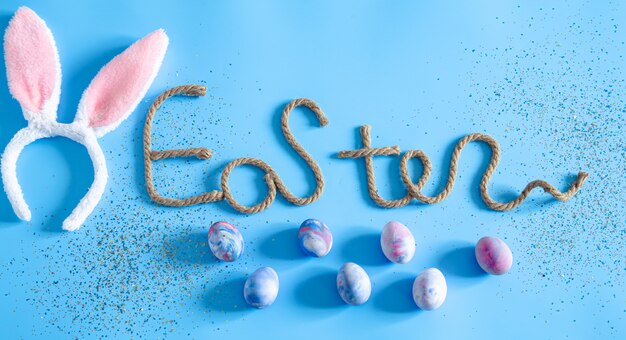 Easter creative inscription on blue with items of Easter decor