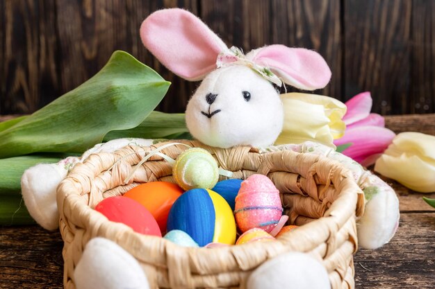 Easter egg decorated in the ukrainian flag colors in the center of the basket of an Easter rabbit