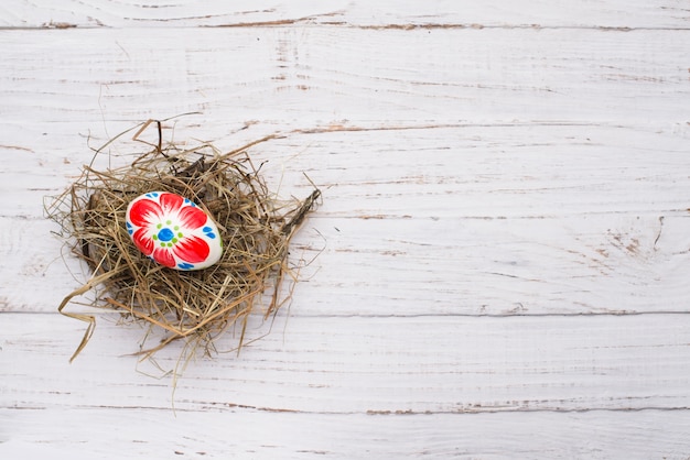 Easter egg over nest on wooden background