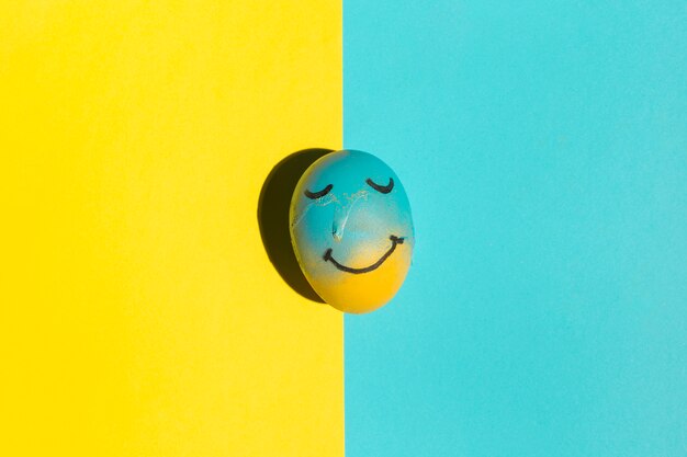 Easter egg with painted smile on table