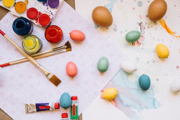 Easter eggs and brushes on table