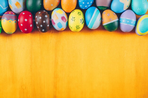 Easter eggs flat lay on yellow wooden background