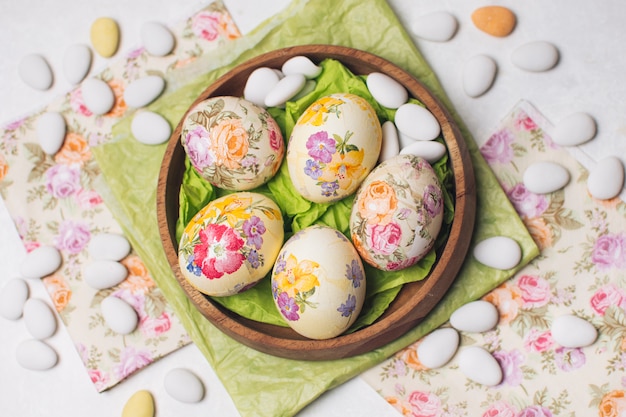Бесплатное фото Пасхальные яйца в миске между салфетками и маленькими камнями