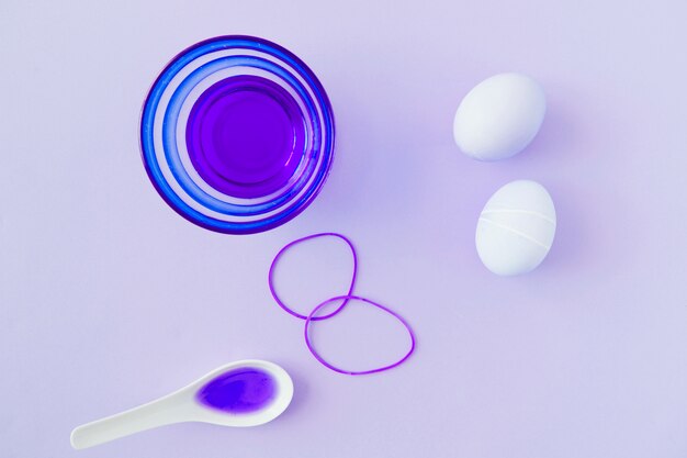 Easter eggs near bowl and spoon with dyes