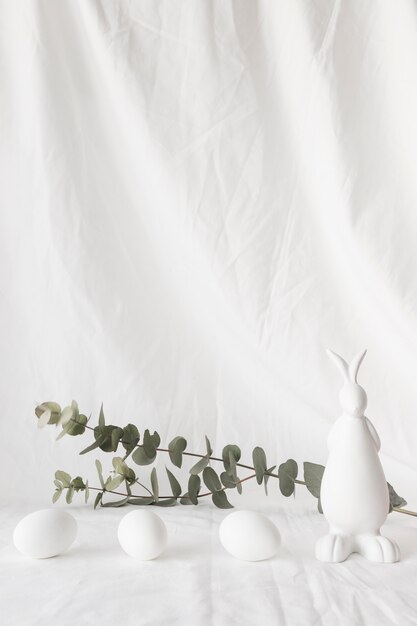식물 나뭇 가지와 토끼의 그림 근처 부활절 달걀