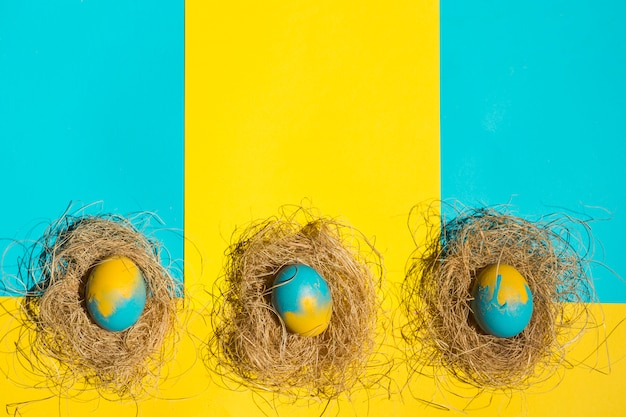 Easter eggs in nests on table 