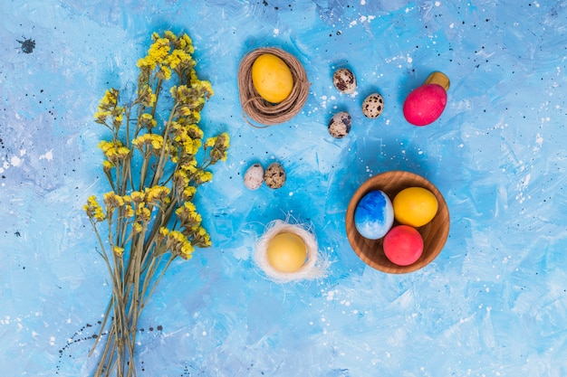 Foto gratuita uova di pasqua in nidi con fiori