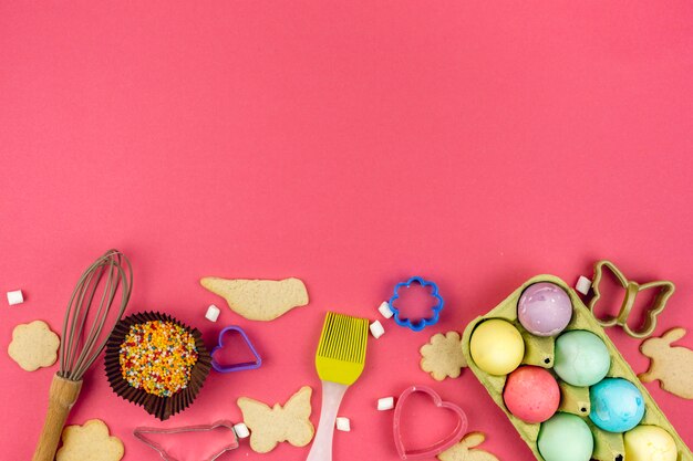 Easter eggs in rack with cookies and kitchen utensils