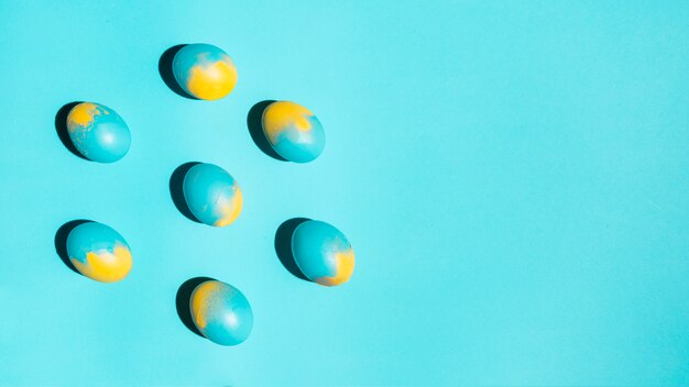 Free photo easter eggs scattered on blue table