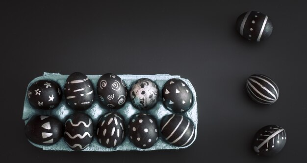 Пасхальные яйца в лотке на черном изолированном столе