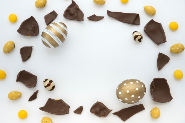 Easter eggs with chocolate pieces on white table