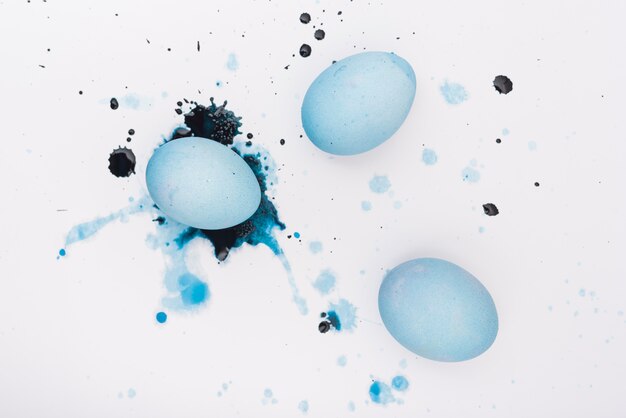 Easter eggs with paint splashes on table
