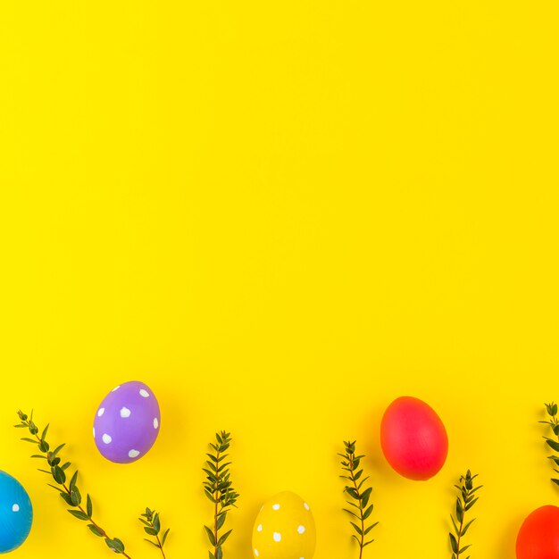 Easter eggs with plant branches on table